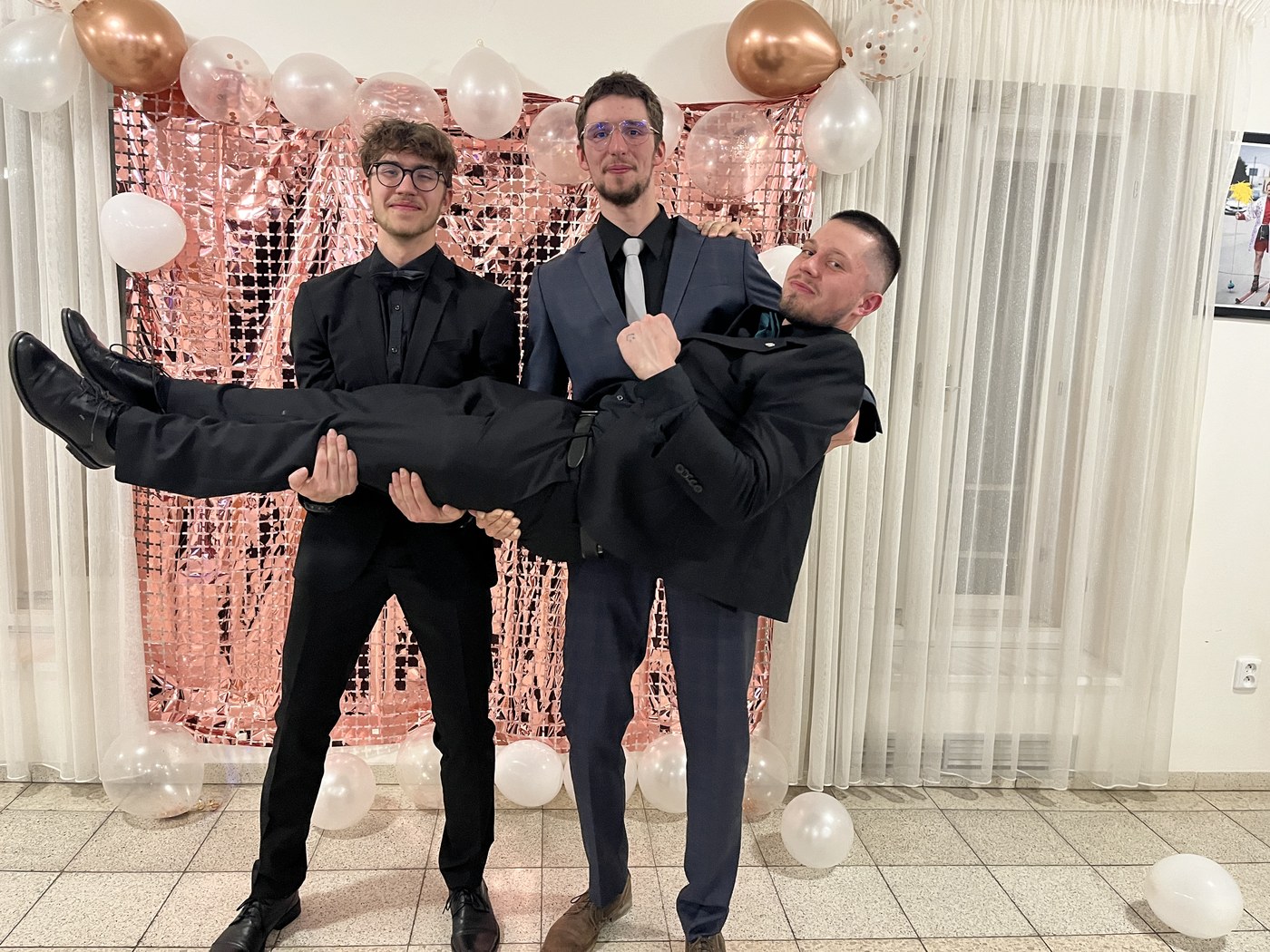 Tři kamarádi ve společenském oblečení na oslavě